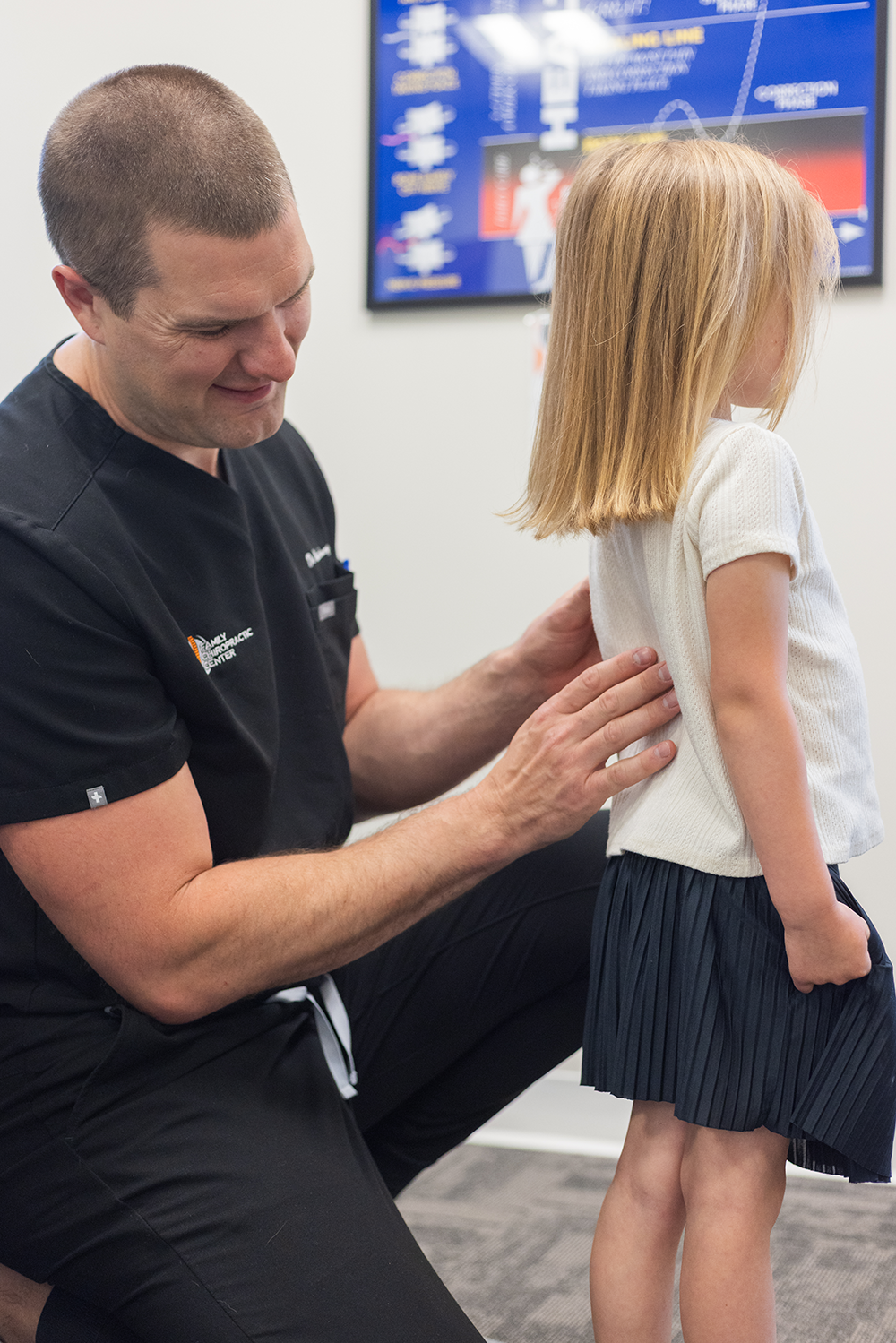 Dr. Kevin Hartung evaluating a child’s posture and spine alignment during a gentle assessment.
